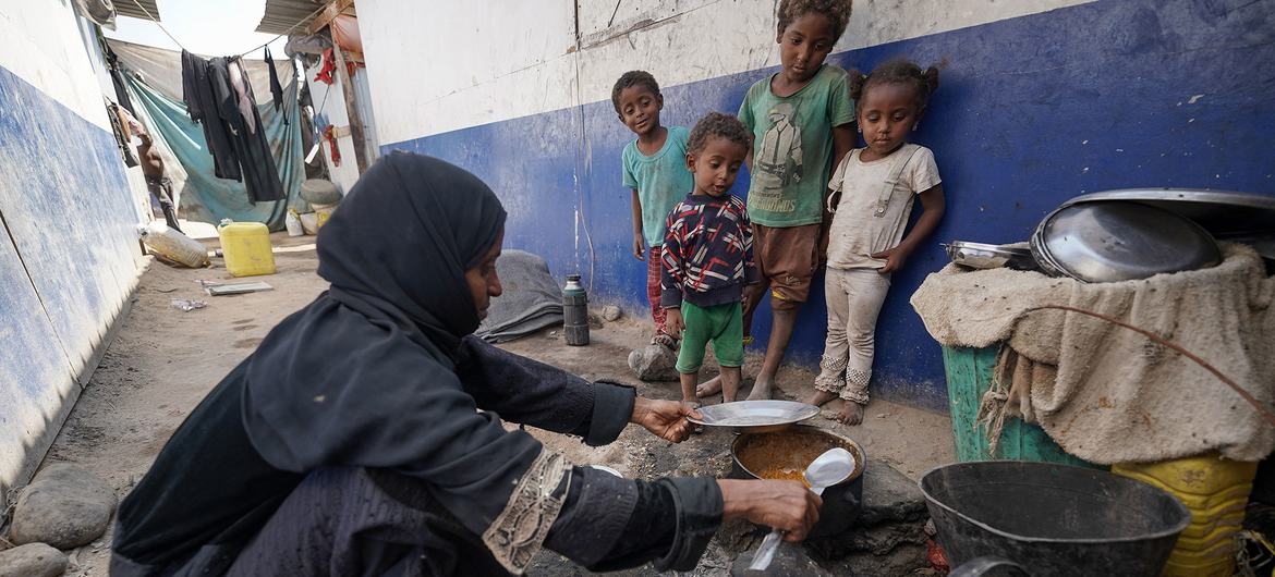 © UNICEF/Saleh Bin Hayan YPN أم يمنية، تعاني من سوء التغذية، تعد طعاما لأطفالها التسعة في مخيم للنازحين في عدن.